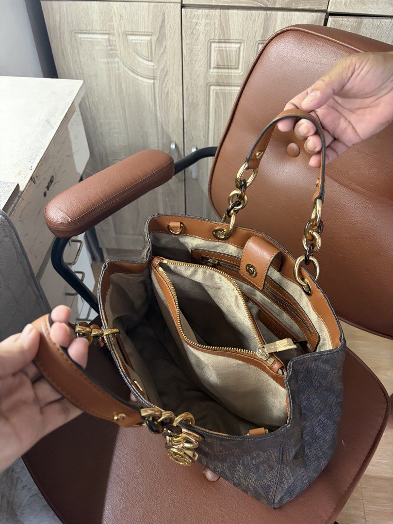 Michael Kors Brown MK Monogram Medium Satchel (Category: Luxury Bags & Wallets) located in Marikina City. Submitted by phelinky_finds (Listing ID 1467085258, Image 3). Description: DESCRIPTION: - Brown Michael Kors tote bag with classic all-over MK monogram print - Elegant gold-tone chain handles paired with matching leather straps (straps still packed, unused) - Signature dangling round MK charm on the front - Spacious and structured interior, p