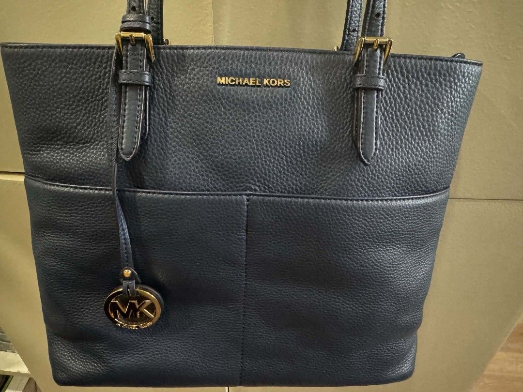 Michael Kors Navy Blue Leather Tote Bag (Category: Tote Bags) located in Las Pinas. Submitted by donatski20 (Listing ID 1466982356, Image 1). Description: - Brand: Michael Kors - Color: Dark Navy Blue - Material: Premium pebbled leather with gold-tone hardware - Includes: Signature MK logo charm and adjustable double shoulder straps - Closure: Secure top-zip closure - Interior: Logo fabric lining, 1 zipper pocket, multiple slip pockets, and a con