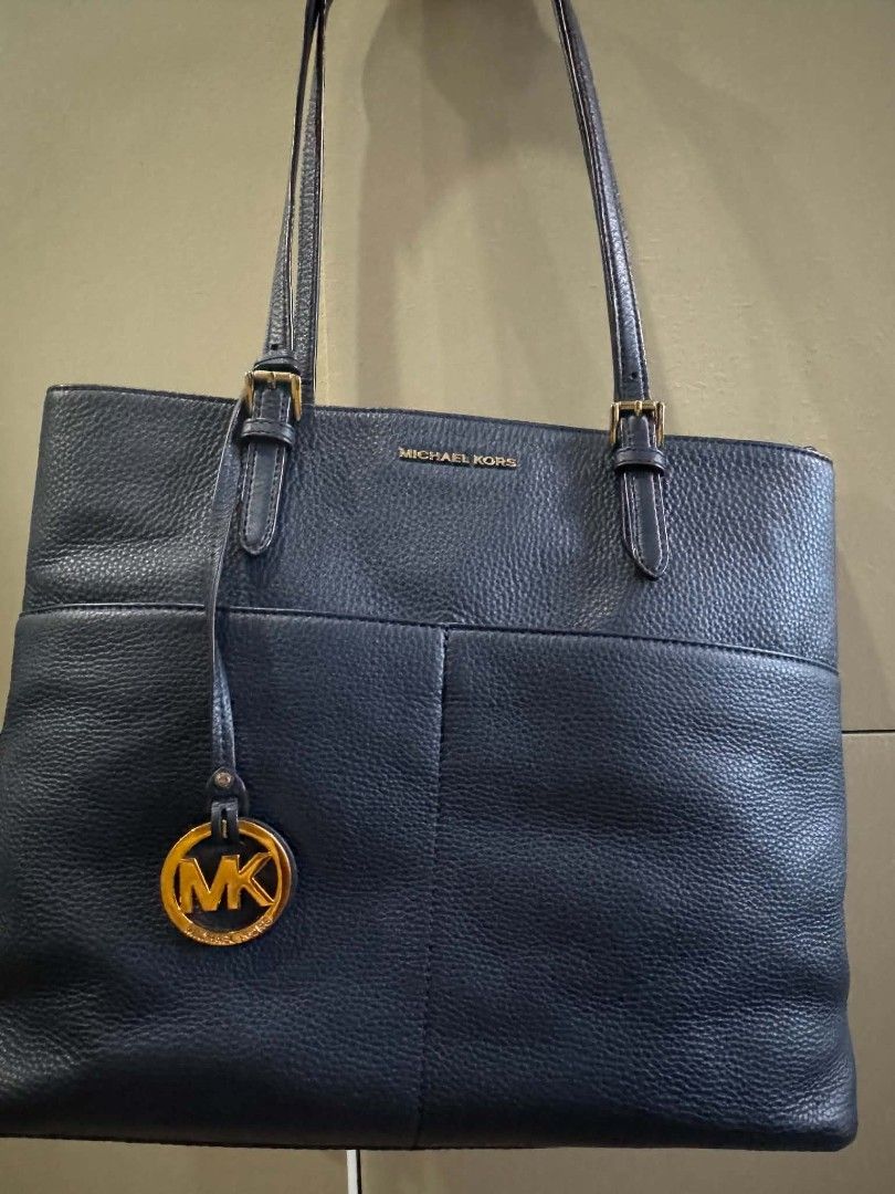 Michael Kors Navy Blue Leather Tote Bag (Category: Tote Bags) located in Las Pinas. Submitted by donatski20 (Listing ID 1466982356, Image 2). Description: - Brand: Michael Kors - Color: Dark Navy Blue - Material: Premium pebbled leather with gold-tone hardware - Includes: Signature MK logo charm and adjustable double shoulder straps - Closure: Secure top-zip closure - Interior: Logo fabric lining, 1 zipper pocket, multiple slip pockets, and a con