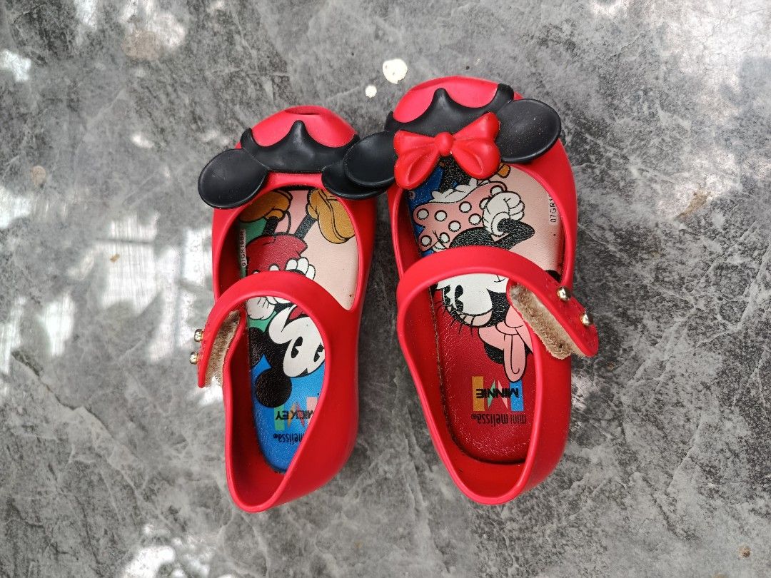 Mini Melissa Disney Mickey Minnie Mouse Red Flats (Category: Babies & Kids Fashion) located in Bacolod City. Submitted by bhebisexy08 (Listing ID 1467008067, Image 2). Description: - Brand: Mini Melissa - Color: Red with black and gold details - Design: Mickey & Minnie Mouse prints on insole, cute 3D mouse ears and red bow on the front - Closure: Strap with gold-tone hardware - Condition: Gently used with light wear on the sole - Perfect for dail