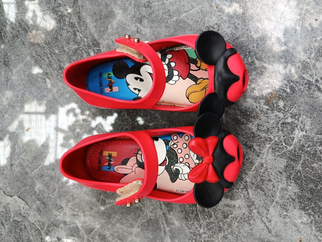 Mini Melissa Disney Mickey Minnie Mouse Red Flats (Category: Babies & Kids Fashion) located in Bacolod City. Submitted by bhebisexy08 (Listing ID 1467008067, Image 1). Description: - Brand: Mini Melissa - Color: Red with black and gold details - Design: Mickey & Minnie Mouse prints on insole, cute 3D mouse ears and red bow on the front - Closure: Strap with gold-tone hardware - Condition: Gently used with light wear on the sole - Perfect for dail