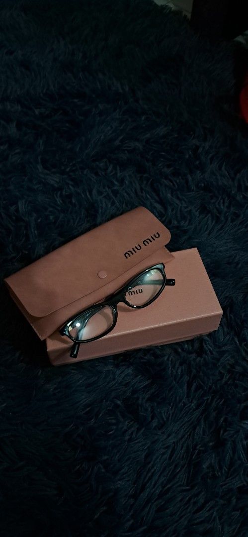 Miu Miu Black Eyeglasses with Case (Category: Luxury Accessories) located in Agdangan. Submitted by crinee_ (Listing ID 1467152411, Image 3). Description: - Color: Black frames with stylish gold accents near the hinges - Lenses: Clear lenses installed (ideal for daily prescription or fashion wear) - Condition: Clean overall condition - Inclusions: Complete set with pink branded box, leather case, cleaning cloth, and authenticity card.