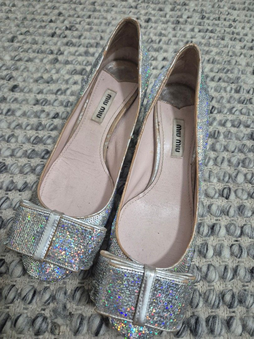 Miu Miu Silver Sequin Bow Pumps Size 37 (Category: Sneakers & Footwear) located in Quezon City. Submitted by 53888 (Listing ID 1467149684, Image 1). Description: - Brand: Miu Miu (Made in Italy) - Size: 37 - Material & Design: Silver holographic sequins with a chunky block heel and adorable toe bow - Details: Pink leather insoles with stamped brand logo - Condition: Pre-loved, worn a few times with minor creasing and slight wear on the inner lini