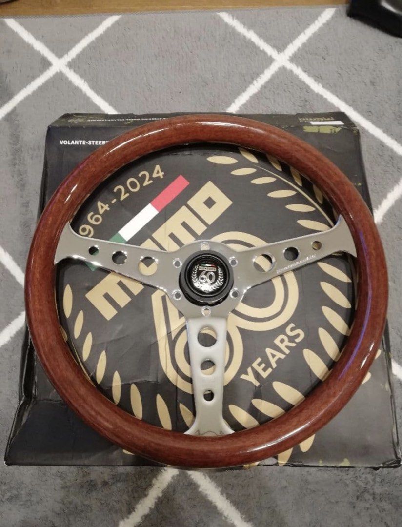 Momo Indy Wood Steering Wheel (Category: Steering, Brakes, Control Parts and Accessories) located in Muntinlupa City. Submitted by vintageboxfinds (Listing ID 1467044174, Image 2). Description: - Authentic Momo Indy wood steering wheel - Features stylish silver slotted spokes and included horn button - Classic vintage style with a natural wood grain rim finish - Ideal upgrade for older car setups and interior restoration projects - Condition: Bra