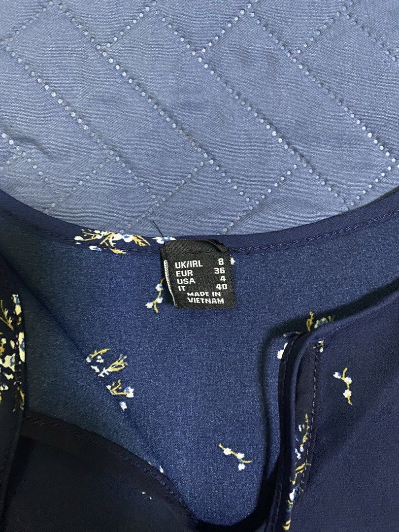Navy Blue Floral Blouse (Category: Blouses) located in Manila. Submitted by escherichiaa (Listing ID 1467140253, Image 2). Description: - Color & Print: Navy blue with white and yellow floral print - Sleeves: Long sleeves with trendy ruffled bell cuffs - Neckline: Scoop neck with front tie-string detail - Fit & Hem: Lightweight fabric with a stylish curved hem (slightly longer in the back) - Size: UK 8, EUR 36, USA 4.