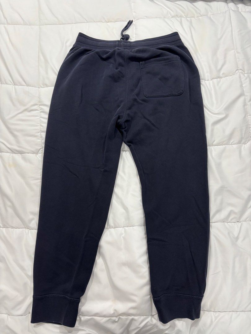 Navy Blue Joggers Drawstring Cuffed Sweatpants (Category: Joggers) located in Manila. Submitted by ethannn_p (Listing ID 1467059553, Image 2). Description: - Color: Navy blue - Material: Soft cotton with cozy fleece lining - Fit: Relaxed fit with ribbed ankle cuffs - Waistband: Adjustable drawstring for a secure fit - Pockets: Two side pockets and one back patch pocket - Condition: Regular wash wear with minor fading along the seams - Perfect for