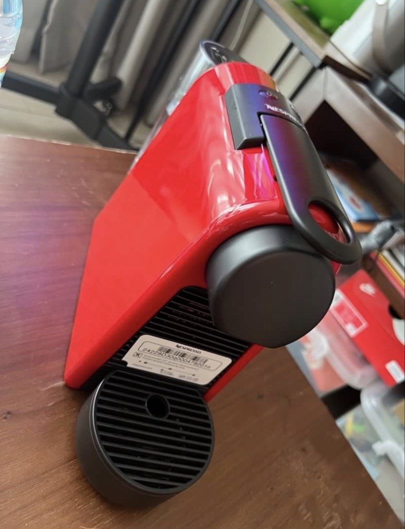 Nespresso Essenza Mini Red Coffee Machine (Category: Coffee Machines & Makers) located in Manila. Submitted by kai.168 (Listing ID 1467163659, Image 2). Description: - Model: Nespresso Essenza Mini - Color: Vibrant Red with a clean gloss finish - Design: Ultra-compact countertop footprint - Features: Two programmable cup size buttons, removable drip tray - Condition: Clean exterior, includes original barcode sticker on the back - Performance: Qui