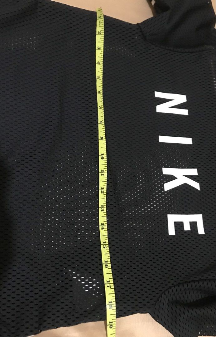 Nike Black Mesh T-Shirt Size S (Category: Shirts) located in Rizal. Submitted by drthriftfour (Listing ID 1466977369, Image 3). Description: - Brand: Nike - Color: Black with large white front logo - Material: Breathable mesh - Size: S (Tag attached) - Measurements: Width 19" across, Length 25" - Design Features: Ribbed neckline, striped trim on sleeves and hem - Condition: Excellent / Ready to wear - Perfect for casual wear or workouts.