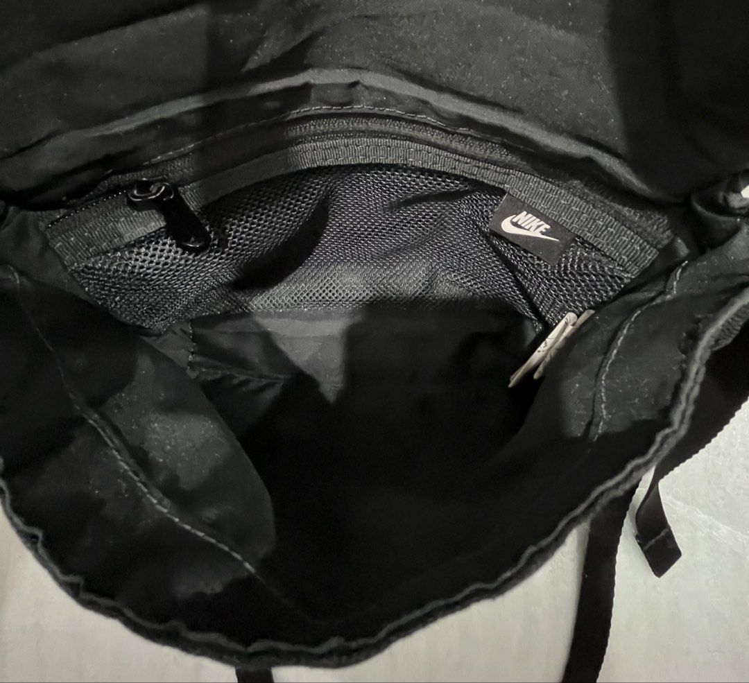 Nike Black Messenger Crossbody Bag (Category: Sling Bags) located in Talisay. Submitted by cherylu (Listing ID 1466975938, Image 2). Description: Black canvas messenger bag from Nike. Large white logo on the front flap. Adjustable shoulder strap. Inside has a zippered mesh pocket with a small Nike tag. Main compartment holds daily essentials. Clean fabric inside and out..