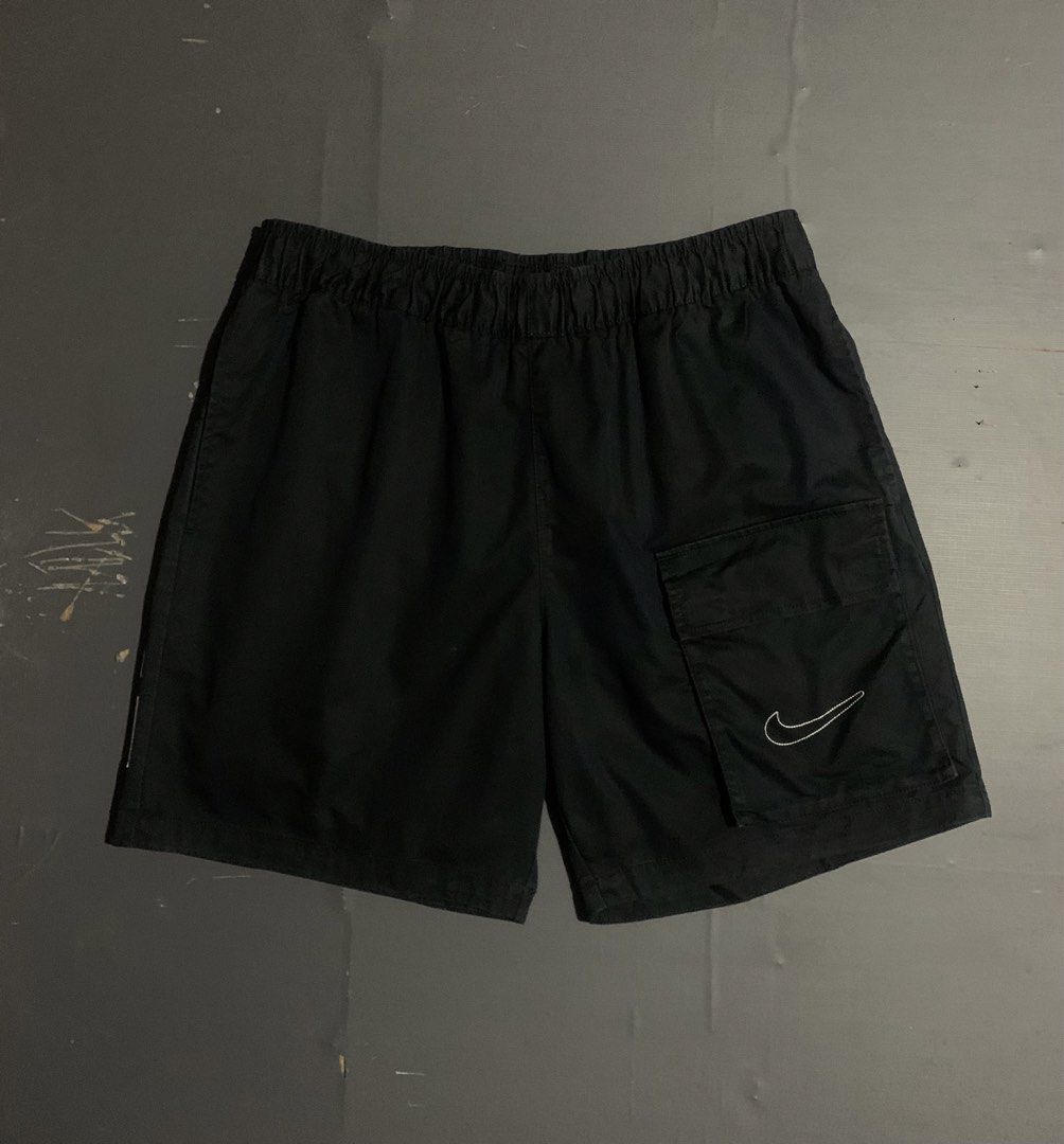 Nike Black Waffle Short (Category: Shorts) located in Dumaguete. Submitted by grrrpowww (Listing ID 1467166664, Image 2). Description: - Brand: Nike - Size: XL - Color: Black with white details - Design: Large vertical Nike logo on the back right leg - Storage: Practical cargo pocket on the left front leg with embroidered white swoosh - Fit/Style: Elastic waistband with white drawstring, comfortable for casual wear or workouts - Origin: Made in C