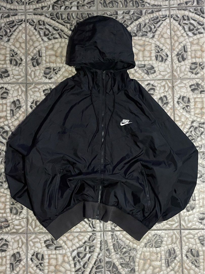Nike Black Windbreaker Jacket with Hood (Category: Coats, Jackets and Outerwear) located in Cavite. Submitted by inzu_ (Listing ID 1467025298, Image 1). Description: - Authentic black Nike windbreaker with matching hood and drawstrings - Full zip front featuring a branded zipper pull - Embroidered white Nike logo on the chest - Ribbed cuffs and hem to lock in warmth and block the wind - Lightweight fabric with convenient side pockets - Standard f