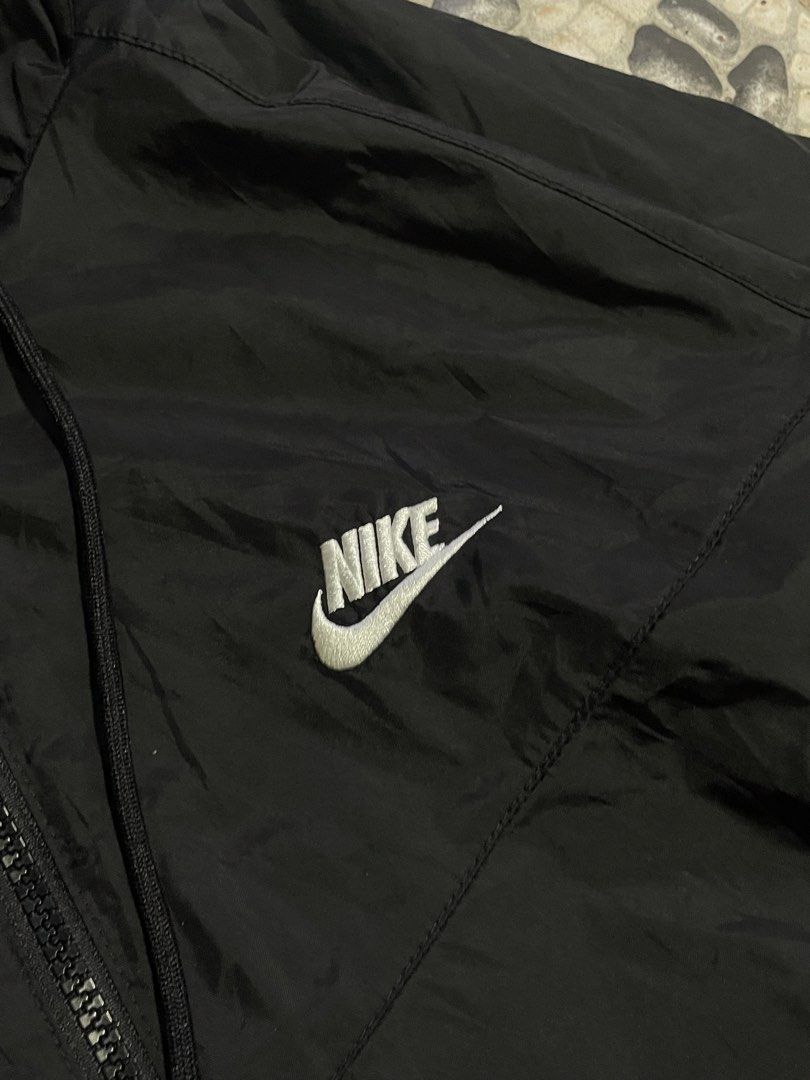 Nike Black Windbreaker Jacket with Hood (Category: Coats, Jackets and Outerwear) located in Cavite. Submitted by inzu_ (Listing ID 1467025298, Image 3). Description: - Authentic black Nike windbreaker with matching hood and drawstrings - Full zip front featuring a branded zipper pull - Embroidered white Nike logo on the chest - Ribbed cuffs and hem to lock in warmth and block the wind - Lightweight fabric with convenient side pockets - Standard f