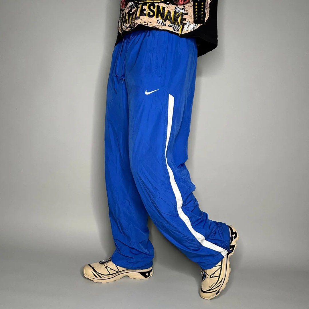 Nike Blue White Stripe Track Pants Size M (Category: Joggers) located in Antipolo. Submitted by switchneighborhood (Listing ID 1467117052, Image 1). Description: - Brand: Nike - Style: Track pants with white side stripes - Color: Blue with embroidered white Swoosh logo on the thigh - Size: Medium - Material: Lightweight nylon with mesh inner lining - Origin: Made in Vietnam - Features: Elastic waistband with adjustable drawstring and lower leg zi