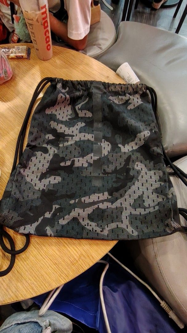 Nike Camouflage Print Gym Sack Drawstring Backpack (Category: Backpacks) located in Manila. Submitted by purediamond888 (Listing ID 1467047260, Image 1). Description: - Brand: Nike - Design: All-over dark camouflage print with vertical branding - Material: Durable, mesh-like textured fabric - Closure: Smooth drawstring for easy access - Storage: Handy side zipper pocket for small essentials - Best for: Gym, sports practice, or casual everyday car