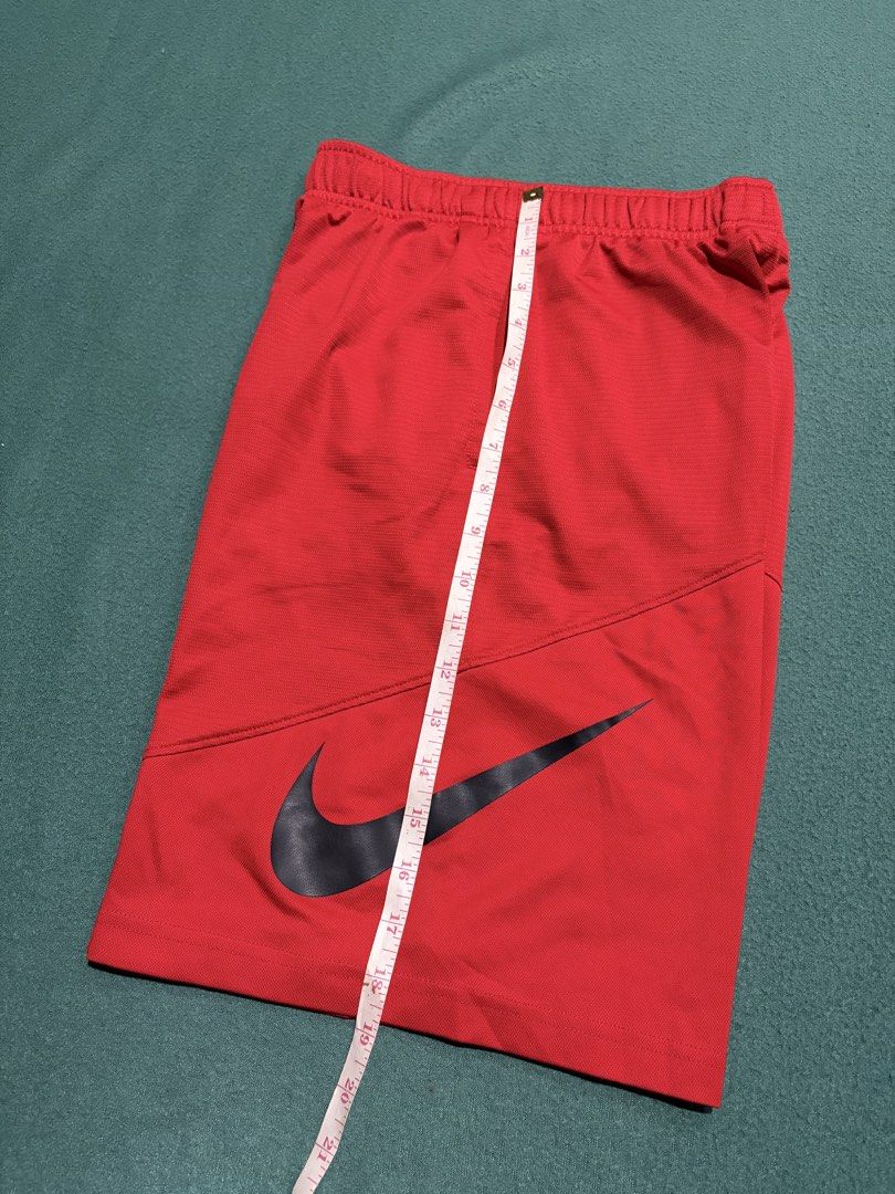 Nike Dri-FIT Red Athletic Shorts Size M (Category: Shorts) located in Guihulngan. Submitted by fbthriftgoodsniace (Listing ID 1467095522, Image 2). Description: - Brand: Nike - Color: Bright red with black Swoosh logo - Size: Medium (M) - Material: Dri-FIT moisture-wicking fabric - Features: Elastic waistband with inner adjustable drawstring - Measurements: ~11.5" flat waist across, ~21" total length - Origin: Made in Thailand - Condition: Excell