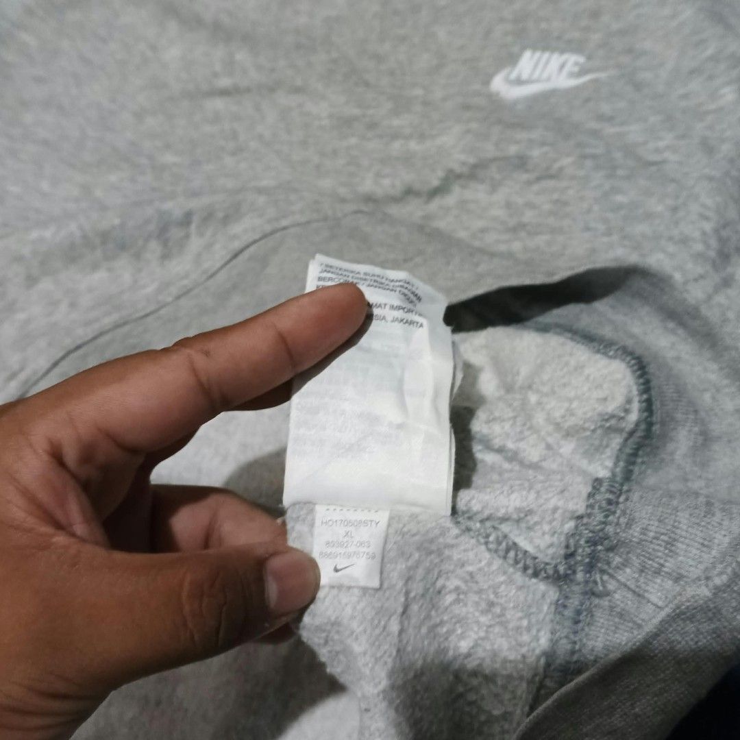 Nike Grey Sweatshirt with Front Pocket (Category: Coats, Jackets and Outerwear) located in Indang. Submitted by shanlennon09 (Listing ID 1467100286, Image 2). Description: - Color: Grey -mens - Brand: Nike - Features: Small white embroidered swoosh on chest, front pouch pocket - Fit: Comfortable relaxed fit - Details: Ribbed collar, cuffs, and hem.