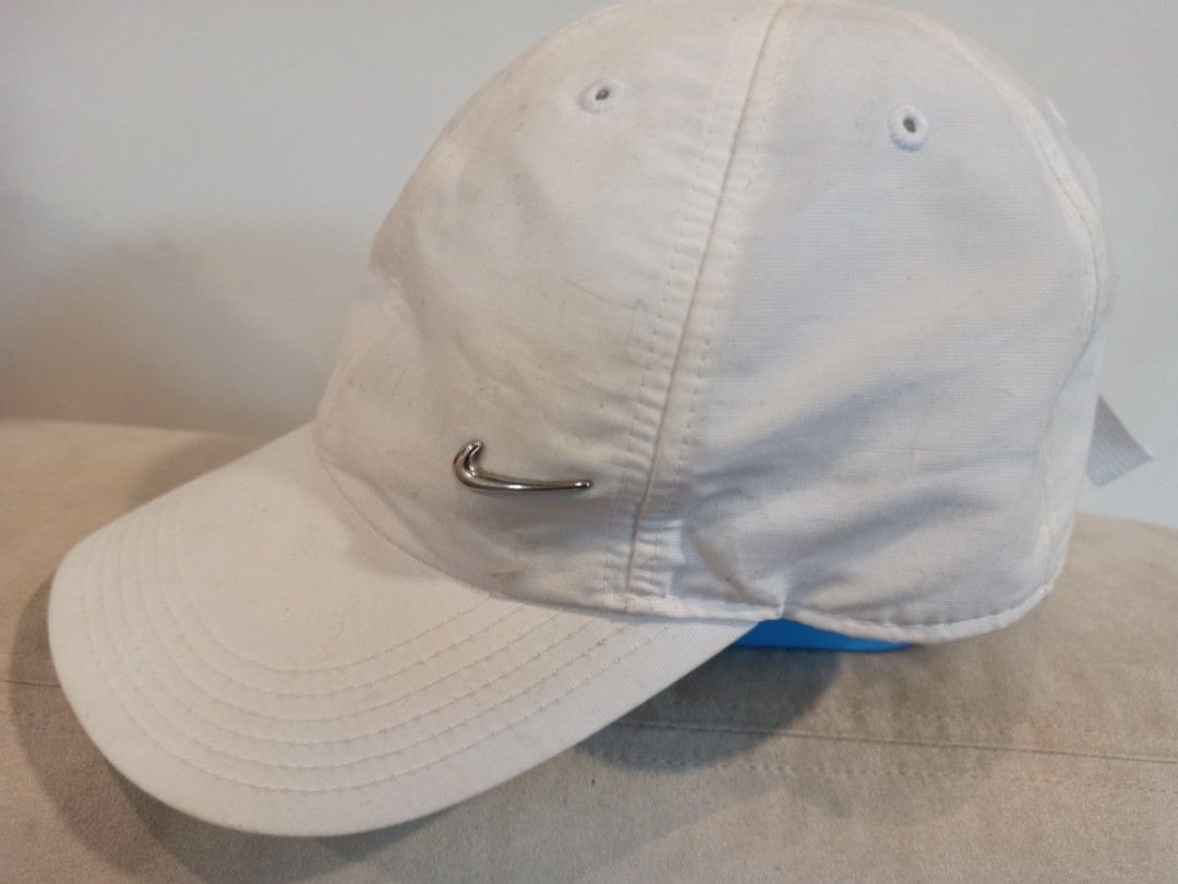 Nike Metal Swoosh White Baseball Cap (Category: Caps & Hats) located in Caloocan City. Submitted by rtarellano (Listing ID 1466980300, Image 2). Description: - Brand: Nike - Color: Classic White - Logo: Sleek silver metal swoosh on the side - Fit: Adjustable strap in the back for a custom fit - Design: Classic baseball hat with embroidered eyelets for breathability - Style: Clean and versatile, easily pairs with any casual outfit.