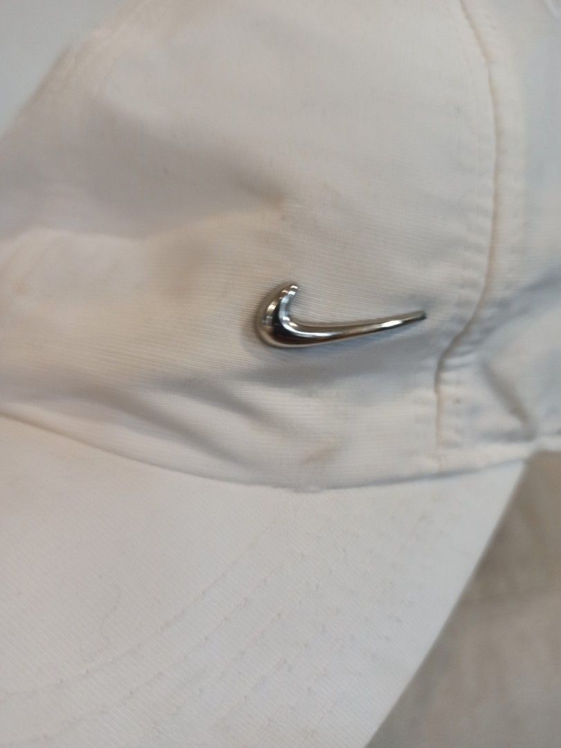 Nike Metal Swoosh White Baseball Cap (Category: Caps & Hats) located in Caloocan City. Submitted by rtarellano (Listing ID 1466980300, Image 3). Description: - Brand: Nike - Color: Classic White - Logo: Sleek silver metal swoosh on the side - Fit: Adjustable strap in the back for a custom fit - Design: Classic baseball hat with embroidered eyelets for breathability - Style: Clean and versatile, easily pairs with any casual outfit.