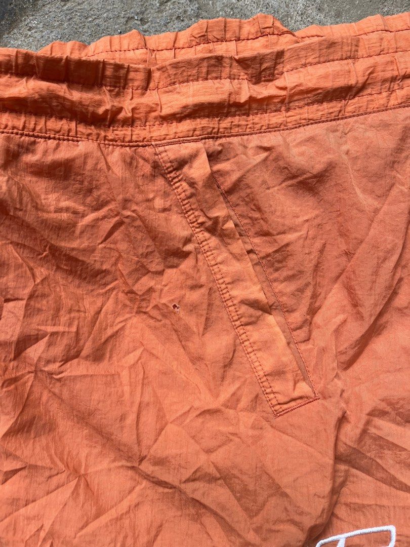 Nike Orange Nylon Shorts with White Drawstring Size L (Category: Shorts) located in Bacolod City. Submitted by ejaybancal2 (Listing ID 1466998501, Image 3). Description: - Brand/Model: Nike orange nylon shorts - Size: L - Material: 100% nylon body, 100% polyester mesh lining - Features: White drawstring waistband and large white Nike logo near bottom hem - Flaw: Tiny hole near the seam on the left leg pocket - Style: Great casual pair for hot day