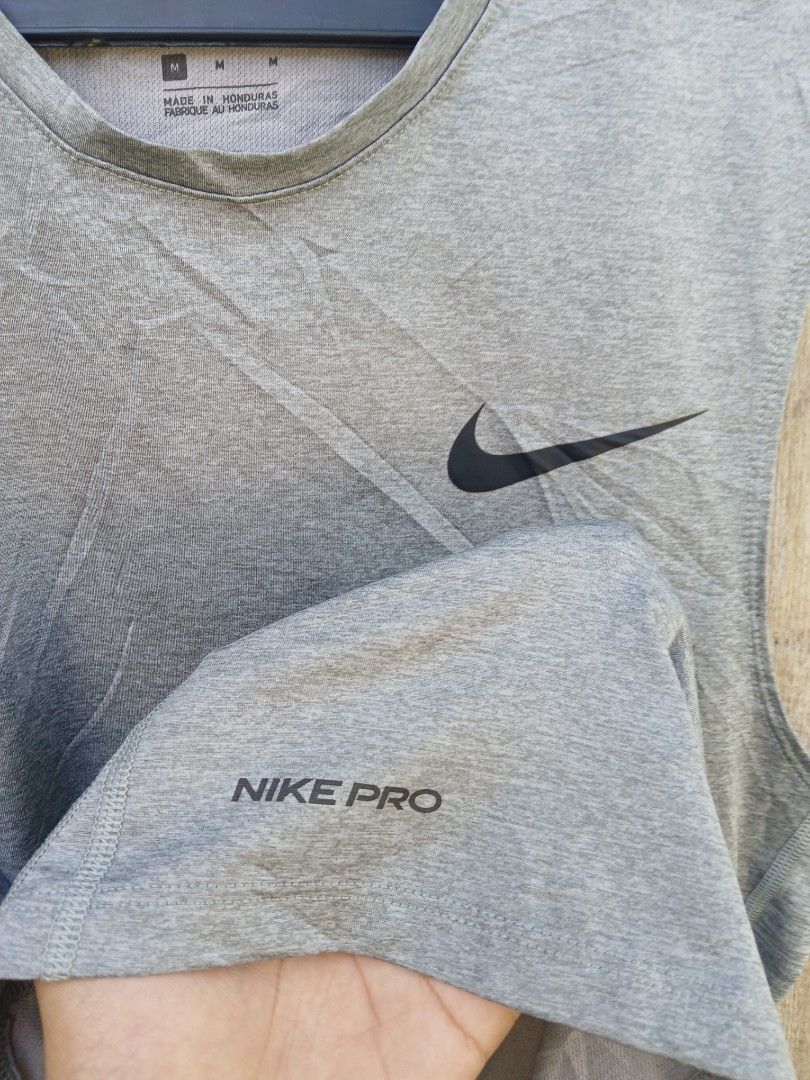 Nike Pro Dri-FIT Grey Tank Top Size M (Category: Activewear) located in Manila. Submitted by thrift_sixty (Listing ID 1467000071, Image 2). Description: Nike Pro sleeveless workout top in grey heather. Size M, made in Honduras. Dri-FIT moisture-wicking fabric keeps you dry during training sessions. Signature Nike swoosh logo on the chest and small Nike Pro branding near the hem. Body made from 93% polyester and 7% spandex. Lightweight, stretchy m