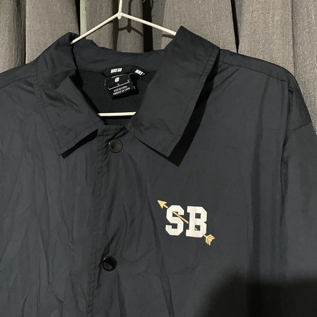 Nike SB Black Coaches Jacket Size L (Category: Coats, Jackets and Outerwear) located in Manila. Submitted by seramisu (Listing ID 1467073825, Image 2). Description: - Authentic Nike SB coach jacket in black, size Large - Snap button closure with classic collar neckline - Adjustable drawstring hem for a custom fit - Distinct white and gold 'SB' graphic printed on the left chest - Official Nike SB inner tag and branding - Versatile outer layer, gre