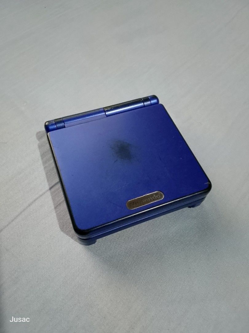 Nintendo Game Boy Advance SP Blue Handheld Console (Category: Nintendo) located in San Felipe. Submitted by jusac_19 (Listing ID 1467079636, Image 2). Description: - Authentic Nintendo Game Boy Advance SP in dark blue - Fully tested and 100% functional with v4 ips screen - Normal cosmetic wear: scuffs and stains on outer casing, plus scratches on bottom label - Clean battery compartment - Ready for your favorite retro games!.