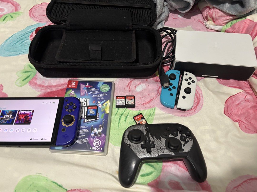 Nintendo Switch Console Bundle with Games and Extra Controllers (Category: Nintendo) located in Victoria. Submitted by rigivernajoy (Listing ID 1467076782, Image 2). Description: - Nintendo Switch console with custom blue Zelda themed casing - White OLED dock, power cord, and HDMI cable included - Extra set of blue and white Joy-Cons and custom black pro controller - Includes protective carrying case - 4 game cartridges: Just Dance 2022, NBA 2K18