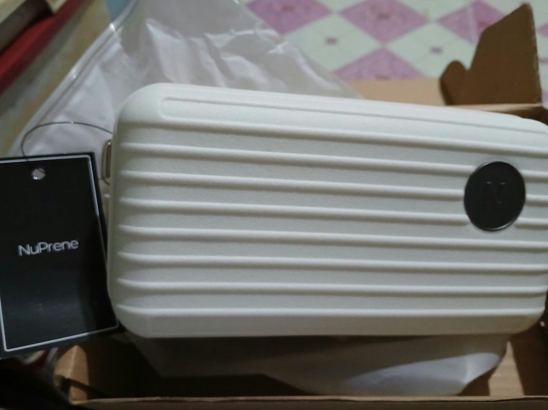 NuPrene white mini suitcase hardshell crossbody bag with strap (Category: Cross-body Bags) located in Manila. Submitted by adeclutteringmoment (Listing ID 1467125870, Image 1). Description: - Brand: NuPrene - Style: Hardshell mini suitcase bag in white - Design: Textured ribbed design with round N logo badge - Strap: Includes matching adjustable webbed strap - Condition: Brand new and unused, comes in original cardboard box - for decluttering - f