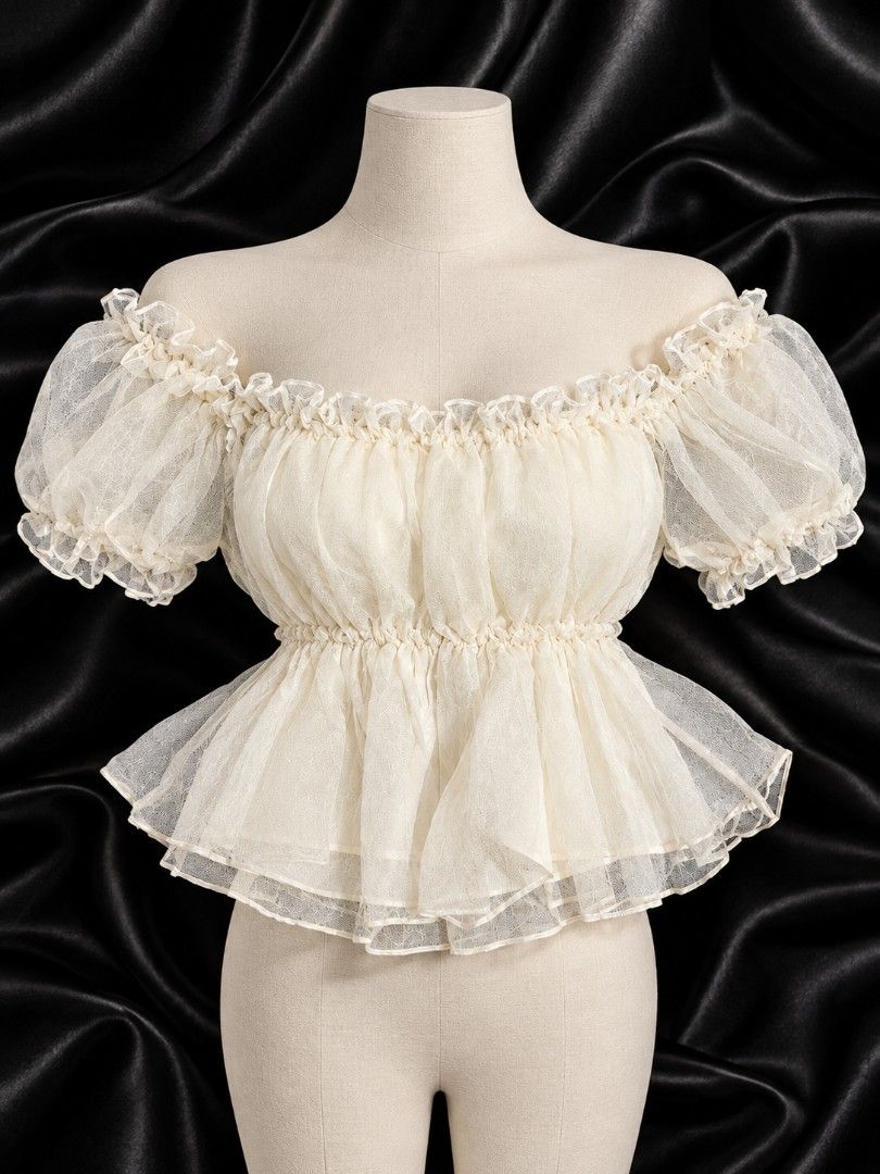 Off-shoulder sheer ruffled puff sleeve top in cream (Category: Blouses) located in Bulacan. Submitted by heathersdream.c0 (Listing ID 1467019204, Image 1). Description: - Color: Cream - Style: Off-shoulder sheer mesh top with short puff sleeves - Details: Smocked bodice with a flared peplum hem and all-over ruffles - Fabric: Lightweight and textured - Aesthetic: Whimsical fairycore vibe - Pairing: Great with denim skirts or high-waist pants.
