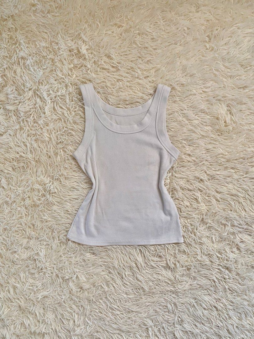 Off-white ribbed tank top basic sleeveless top (Category: Sleeveless) located in Guagua. Submitted by zenn_vi (Listing ID 1467132817, Image 1). Description: - Color: Off-white - Material: Soft stretch cotton - Design: Wide scoop neckline with thick straps - Fit: Basic solid color, easy to pair with any bottoms or layer under jackets - Condition: Clean fabric and neat neckline stitching - Style: Great daily staple for warm weather or layering.