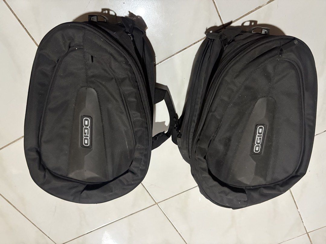 Ogio Motorcycle Saddle Bag Pair (Category: Helmets and other Riding Gears) located in Manila. Submitted by gentlecloud_71412b (Listing ID 1467166333, Image 1). Description: - Brand: Ogio - Color: Black - Condition: Good, normal signs of previous mounting use - Features: Durable construction with molded side panels and branded logo inserts - Convenience: Sturdy carry handles and built-in rain hood compartments on the zippers - Capacity: Great stor