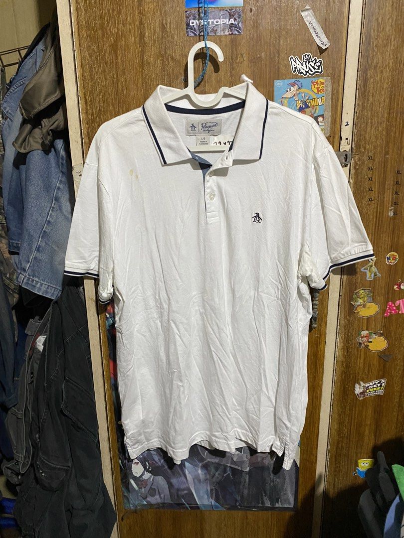 Original Penguin White Polo Shirt Large (Category: Tshirts & Polo Shirts ) located in Imus. Submitted by frootiloots4103 (Listing ID 1467154338, Image 1). Description: - Brand: Original Penguin - Color: White with navy blue collar tipping and inner placket - Size: Large 22x27 - Material: 100% Cotton - Details: Small embroidered penguin logo on the chest, made in Cambodia - Condition: Pre-loved with a couple of visible light stains on the front ri