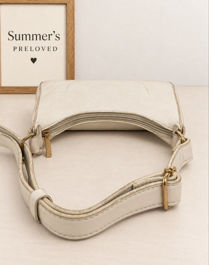 Parisian (Category: Shoulder Bags) located in Taguig. Submitted by summers.preloved (Listing ID 1467119976, Image 3). Description: 👜 BAG DETAILS 🤍 Ivory / cream exterior — A soft neutral shade with a subtle surface texture and understated finish. 🌙 Curved shoulder-bag silhouette — A dipped top opening, gently tapered sides, and rounded bottom corners create a relaxed hobo-style shape. 🪡 Stitched borders and piping — Matching trim outlines the