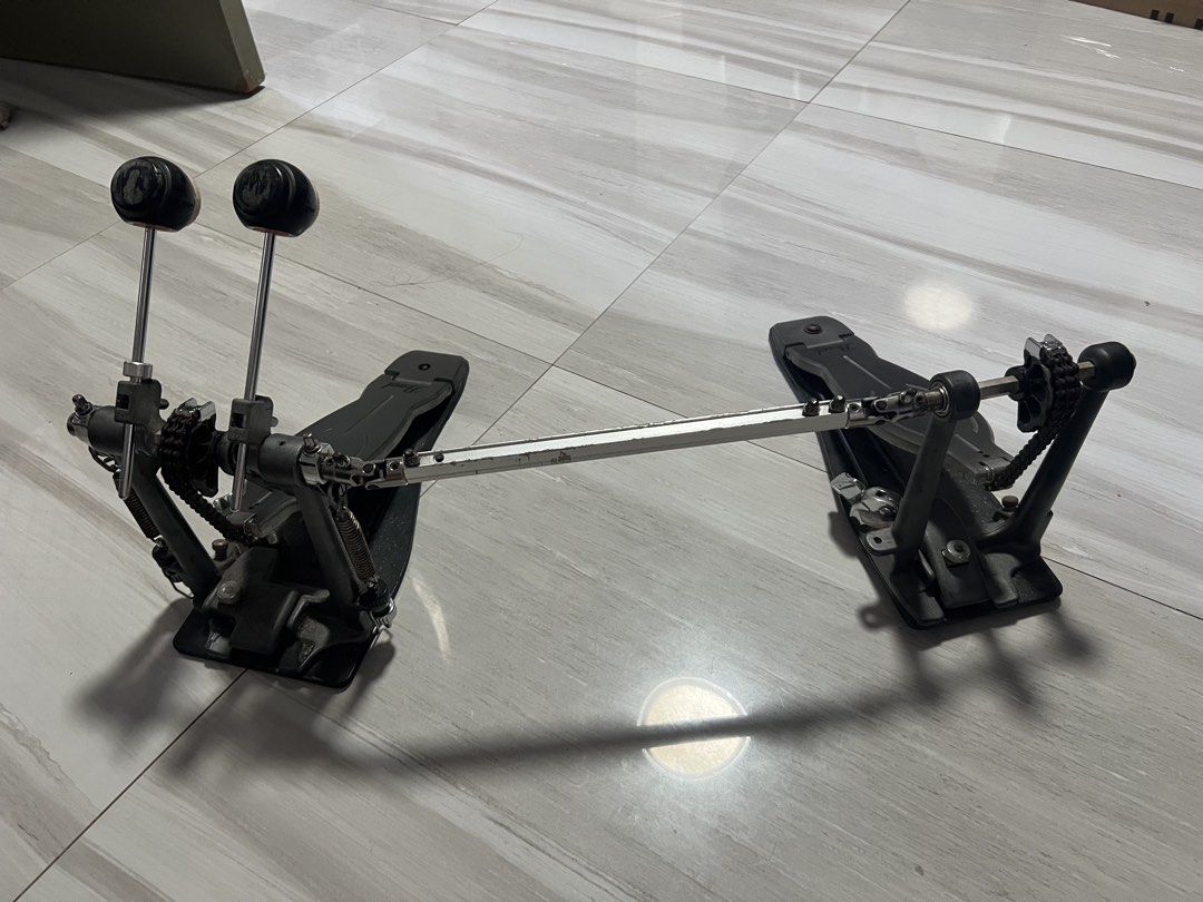 Pearl Double Bass Drum Pedal (Category: Musical Instruments) located in Makati City. Submitted by raymonddr52055 (Listing ID 1466989545, Image 1). Description: - Brand: Pearl double bass drum pedal setup - Drive: Dual chain drive for solid response - Inclusions: Original beaters and connecting drive shaft included - Condition: Fully functional, with standard wear and some surface rust on chains and tension rods - 1 screw replaced - Features: Stur