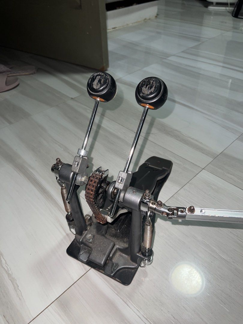 Pearl Double Bass Drum Pedal (Category: Musical Instruments) located in Makati City. Submitted by raymonddr52055 (Listing ID 1466989545, Image 3). Description: - Brand: Pearl double bass drum pedal setup - Drive: Dual chain drive for solid response - Inclusions: Original beaters and connecting drive shaft included - Condition: Fully functional, with standard wear and some surface rust on chains and tension rods - 1 screw replaced - Features: Stur