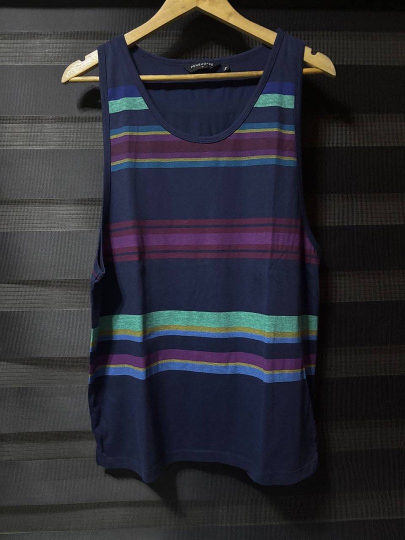 Penshoppe Striped Tank Top (Category: Activewear) located in Pasig City. Submitted by abogadosupremo (Listing ID 1467032368, Image 1). Description: - Brand: Penshoppe - Color: Navy blue with purple, green, and blue horizontal stripes - Material: Lightweight cotton - Fit: Standard fit with scoop neckline and sleeveless cut - Condition: Clean inside and out, from a smoke-free home - Ideal for: Casual wear, summer days, or gym workouts - 100% Legit 