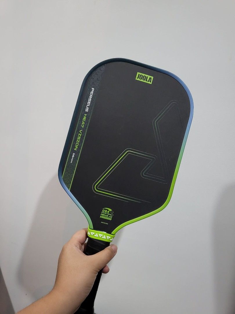 Pickleball Paddle (Category: Racket and Ball Sports) located in Manila. Submitted by jellycalica (Listing ID 1467125015, Image 2). Description: FOR SALE: JOOLA Perseus Heat Vision 16mm Pickleball Paddle Original Price: ₱7,000 Selling Price: ₱5,800 Condition: Used for 1 week only, well-maintained Minimal dents, (doesn't affect performance) USAPA and PBCOR Approved Ready to use Inclusions: ✅ Edge guard ✅ Paddle Cover ✅ Free balls ✅ Free bag RFS: Na