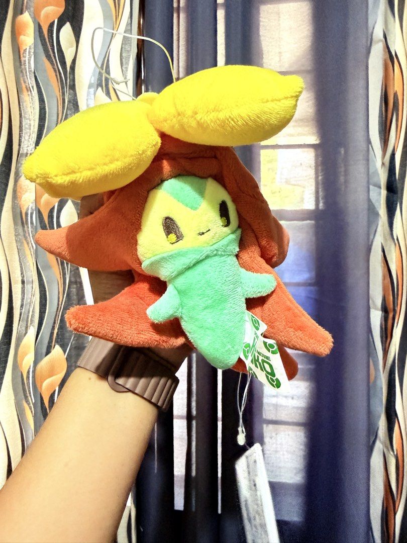 Pokemon Gossifleur Plush Toy (Category: Plushies & Soft Toys) located in Cavite. Submitted by projectplushie (Listing ID 1466994104, Image 1). Description: - Features green and yellow body inside a reddish-orange hooded shell with yellow petals on top - Includes original tags attached on the side and hanging string on top - Clean, well-kept condition, perfect for collectors and fans.