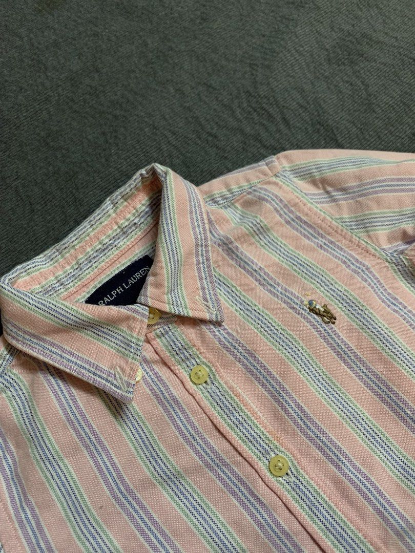 Polo kid Ralph Lauren Striped Button (Category: Tshirts & Polo Shirts ) located in Manila. Submitted by kennethcab79976 (Listing ID 1467018823, Image 2). Description: - Brand: Ralph Lauren - Style: Long-sleeve button-down shirt with classic collar - Color/Pattern: Pink background with green and blue vertical stripes - Details: Signature embroidered polo player logo on chest, front button closure, button cuffs - Material: Soft, high-quality cotton