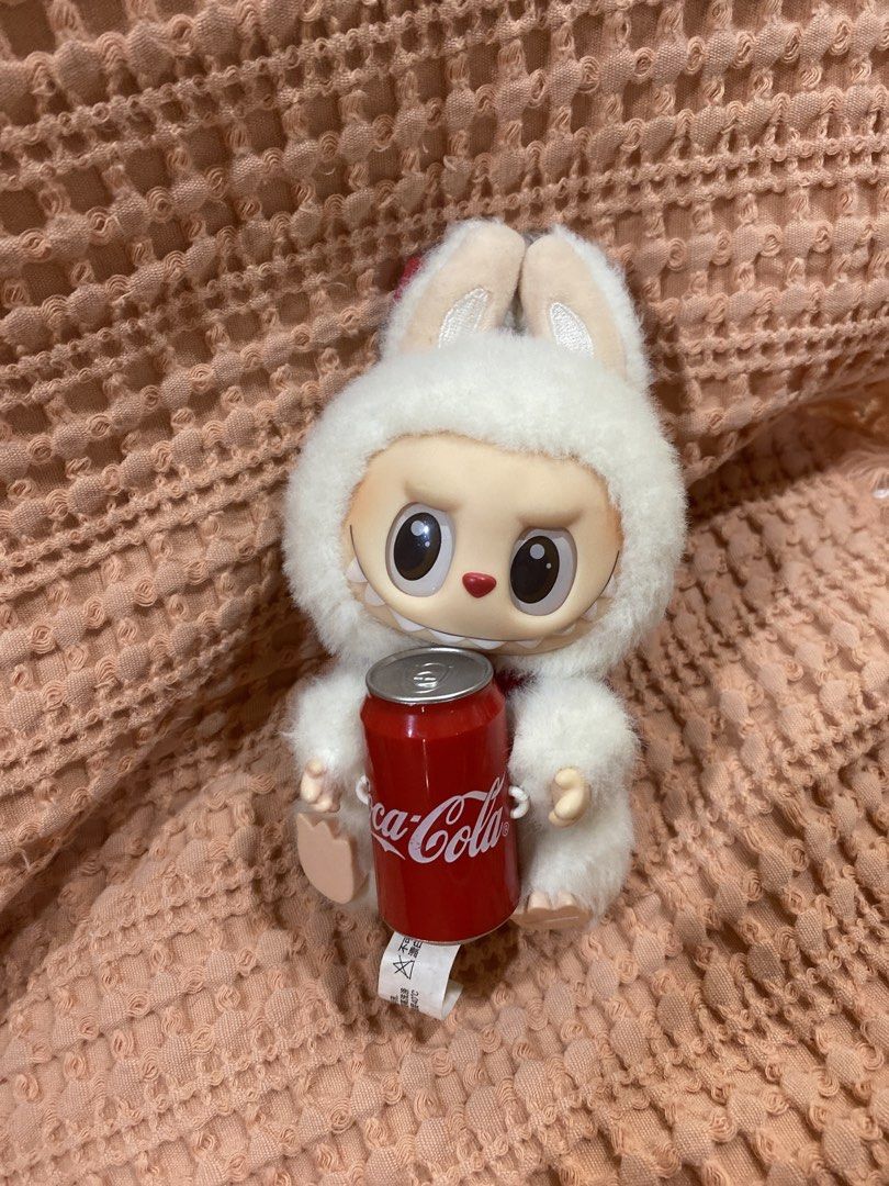 POPMART LABUBU COKE CAN (no box :() (Category: Plushies & Soft Toys) located in Manila. Submitted by ysabaw (Listing ID 1466982360, Image 1). Description: -My kuya bought for me, but not my style anymore - Authentic Pop Mart x Coca-Cola Labubu plush pendant (No BOX) - Adorable fluffy white bunny hat design holding a mini red Coca-Cola can - Features a convenient red keyring at the top - Authenticity markings stamped on the foot with original tags