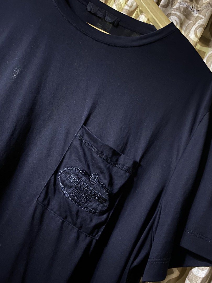 Prada Black Pocket T-Shirt Size L (Category: Tshirts & Polo Shirts ) located in Manila. Submitted by kentmarion.water (Listing ID 1467128520, Image 2). Description: - Brand: Prada - Color: Solid Black - Size: Large (L) - Material: 100% Cotton (Made in Tunisia) - Fit: Regular fit, standard length - Design: Crew neck, short sleeves, chest pocket with embroidered Prada Milano logo patch - Condition: Brand new / Excellent quality - Mode of Payment: G