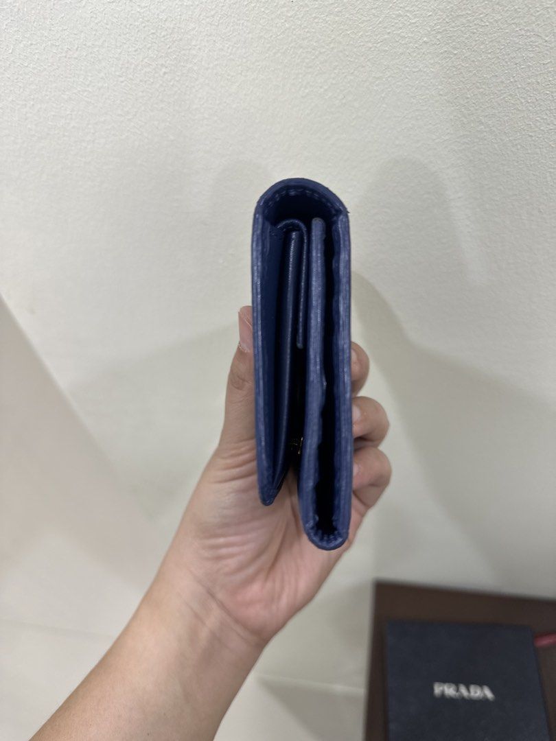 Prada Blue Saffiano Leather Wallet (Category: Luxury Bags & Wallets) located in Paranaque City. Submitted by mycloset1o1 (Listing ID 1467078117, Image 2). Description: - Authentic Prada wallet in deep blue Saffiano leather - Elegant gold-toned hardware with classic Prada Milano front logo - Compact fold design featuring multiple compartments for cards and cash - Clean structure with a sturdy build for everyday use - Original box included Like new