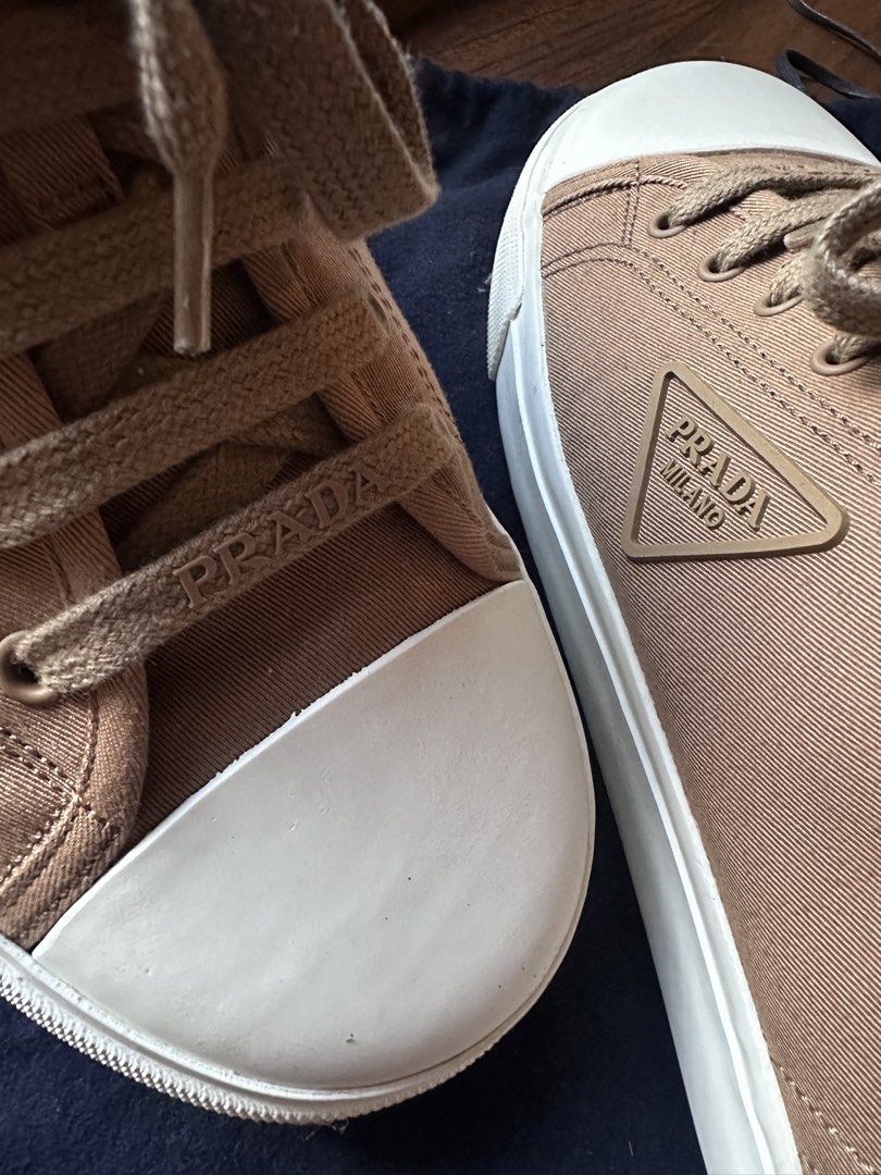 Prada Canvas Sneakers Size 10 (Category: Sneakers) located in San Juan City. Submitted by travellingpete (Listing ID 1467043060, Image 2). Description: - Brand: Prada - Model: 2EE430 - Color: Beige / Tan - Size: US 11 / UK 10 (Made in Spain) - Condition: Clean soles, crisp uppers - Key Features: Rubber toe cap, iconic side triangle logo, embossed Prada laces, branded rubber heel patch - Inclusions: Original dust bag - 100% authentic, well-maintai