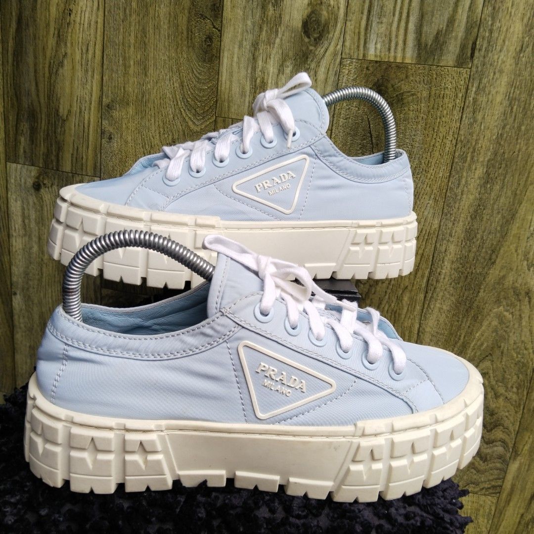 Prada Platform Sneakers Light Blue (Category: Sneakers) located in Lubao. Submitted by dione_closet503 (Listing ID 1467131299, Image 1). Description: - Authentic Prada platform sneakers in a chic light blue shade - Distinctive white chunky rubber soles with textured tread pattern - Signature triangular Prada Milano logo badge on the side panel - Classic white lace-up front closure - Shoe trees included to keep their pristine shape - Elevates any 