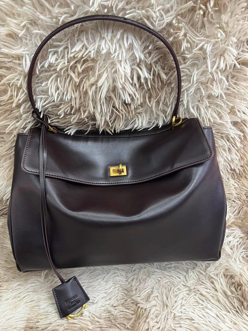 Preloved Balenciaga Rodeo Handbag Brown (Category: Luxury Bags & Wallets) located in Manila. Submitted by bagsandmanymanymore1 (Listing ID 1467077653, Image 2). Description: - Preloved Rodeo Leather Bag - Model: Rodeo Bag -Size 40cm - Color: Dark Brown - Material: Premium Leather - Hardware: Gold-tone - Closure: Front flap with twist lock - Features: Top handle, detachable shoulder strap, and leather tag charm - Interior: Multiple compartments an