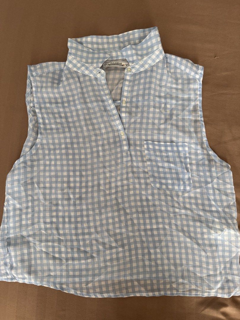 Pull&Bear Blue and White Gingham Sleeveless Blouse (Category: Sleeveless) located in Manila. Submitted by maliwana.gan (Listing ID 1467028102, Image 1). Description: Fits S to M Loc: Tomas Morato, QC Lalamove c/o buyer - Brand: Pull&Bear - Style: Light blue and white gingham sleeveless blouse - Size: Large (EUR L, MEX 30) - Details: Mandarin collar, partial front button placket, right chest pocket - Fabric: Lightweight, ideal for warm weather - C