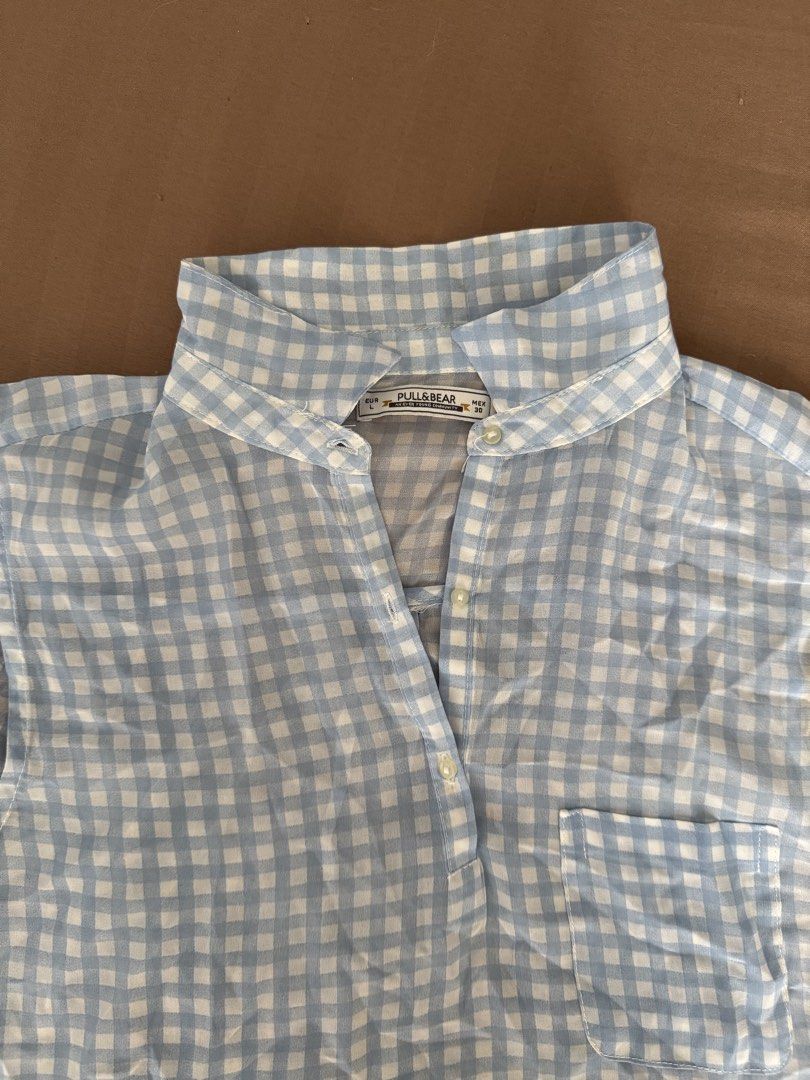 Pull&Bear Blue and White Gingham Sleeveless Blouse (Category: Sleeveless) located in Manila. Submitted by maliwana.gan (Listing ID 1467028102, Image 2). Description: Fits S to M Loc: Tomas Morato, QC Lalamove c/o buyer - Brand: Pull&Bear - Style: Light blue and white gingham sleeveless blouse - Size: Large (EUR L, MEX 30) - Details: Mandarin collar, partial front button placket, right chest pocket - Fabric: Lightweight, ideal for warm weather - C