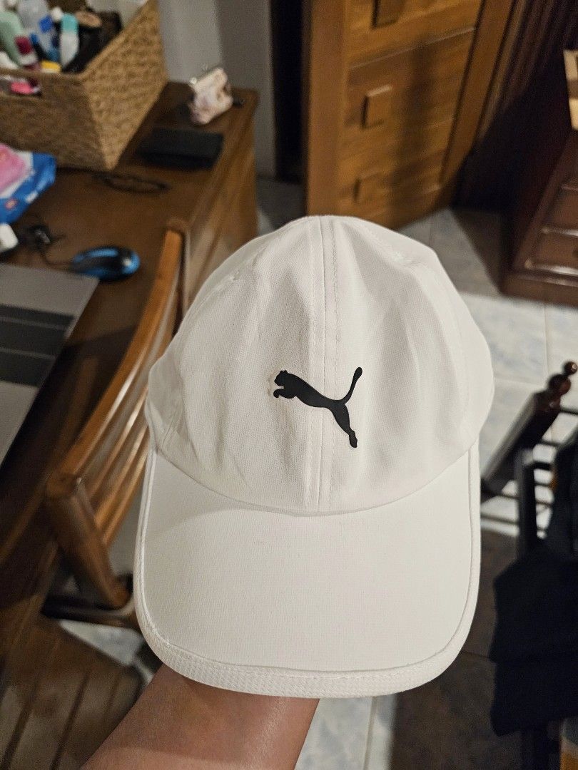 Puma White Sport Cap OSFA (Category: Caps & Hats) located in Makati City. Submitted by richpaul_ (Listing ID 1467167218, Image 1). Description: - Authentic Puma baseball cap in classic white - Features iconic black leaping cat logo on the front - Moisture-wicking grey sweatband for maximum comfort during workouts - Made from 90% polyester and 10% spandex (lightweight and flexible) - Adjustable back strap with small Puma logo tag for a custom fit 