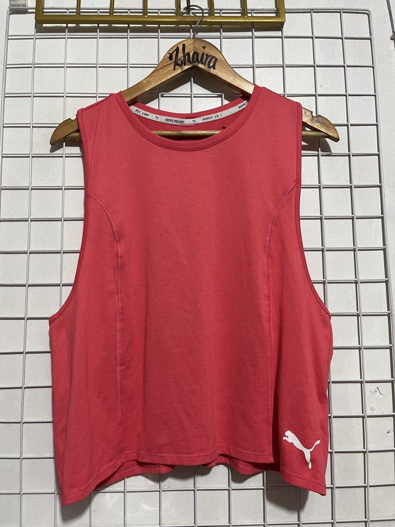 Puma Workout Tank Top Racerback Size L (Category: Activewear) located in Pagsanjan. Submitted by zhairaaaaa (Listing ID 1467099629, Image 3). Description: Puma red sleeveless top for workouts or casual wear. Size L on tag. Features 'KEEPS YOU DRY' taping inside the collar and a bold Puma logo tape running down the back spine. Small white Puma cat logo printed near the bottom hem on the front. Racerback cut for movement. Fabric feels lightweight a