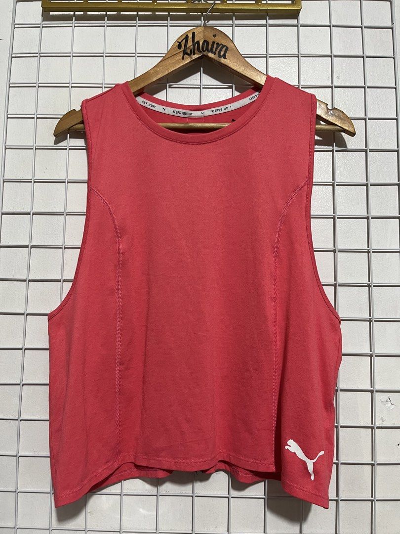 Puma Workout Tank Top Racerback Size L (Category: Activewear) located in Pagsanjan. Submitted by zhairaaaaa (Listing ID 1467099629, Image 2). Description: Puma red sleeveless top for workouts or casual wear. Size L on tag. Features 'KEEPS YOU DRY' taping inside the collar and a bold Puma logo tape running down the back spine. Small white Puma cat logo printed near the bottom hem on the front. Racerback cut for movement. Fabric feels lightweight a